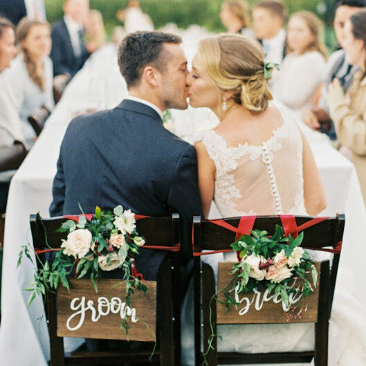 Newlyweds at their reception with custom chair signage